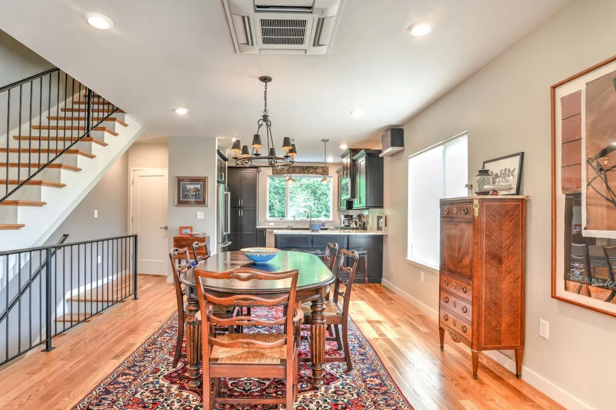 A view of the dining area that also highlights a staircase and part of the kitchen. This perspective subtly references the multi-level design and easy movement between spaces, which ties in with the private elevator and thoughtful layout.